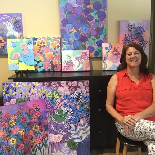 Artist Suzanne Redmond with her flower paintings
